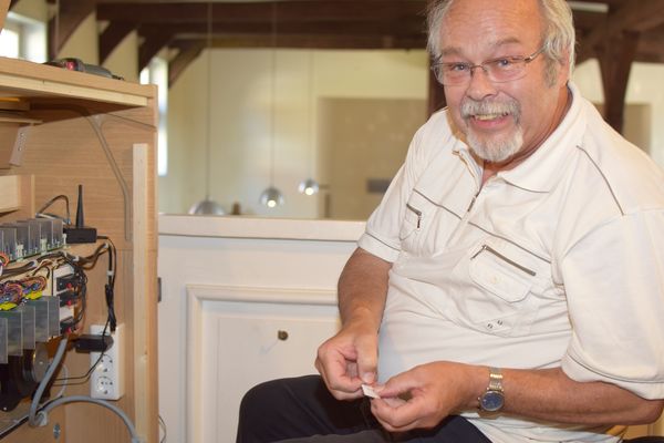 Dr. Michael Uhrmacher hält eine neuprogrammierte Speicherkarte in den Händen, um sie im Orgelkasten einzuschieben.