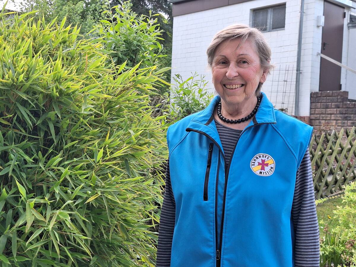 Das Foto zeigt eine Frau in einer blauen Weste der Bahnhofsmission.