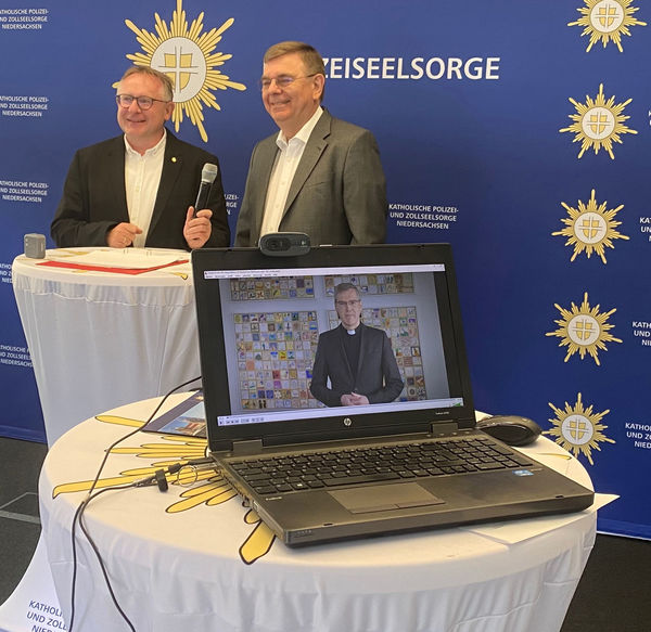 Torsten Thiel und Joachim Michalik lauschen den Worten von Bischof Dr. Heiner Willmer SCJ, der per Video die Teilnehmer der virtuellen Tagung grüßte.